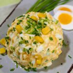 Ein frischer Eiersalat, dekorativ auf einem Teller angerichtet, garniert mit frischem Dill und Schnittlauch, garniert mir gekochten Eiern