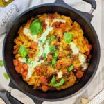 Ein köstliches Tomaten-Mozzarella-Gratin, frisch aus dem Ofen mit goldbrauner, knuspriger Käseschicht, garniert mit frischem Basilikum.